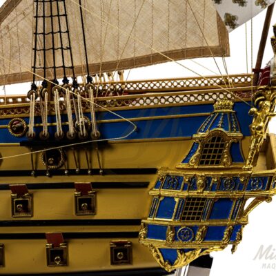 Arrière de L’Ambitieux, maquette du vaisseau royal ornée de sculptures dorées et de pavillons fleurdelisés.