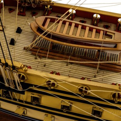 Ponts détaillés de la maquette de L’Ambitieux avec embarcations, canons et décorations fidèles au XVIIe siècle.