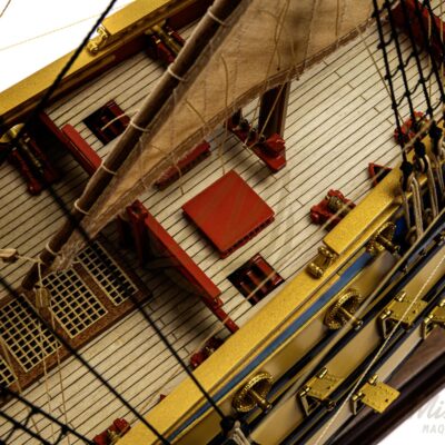 Ponts détaillés de la maquette de L’Ambitieux avec embarcations, canons et décorations fidèles au XVIIe siècle.