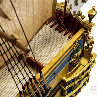Ponts détaillés de la maquette de L’Ambitieux avec embarcations, canons et décorations fidèles au XVIIe siècle.