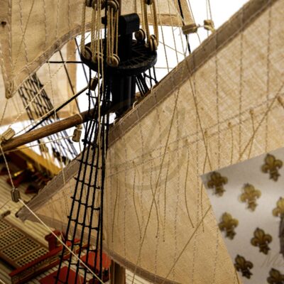 Gréement détaillé et voiles en tissu de la maquette artisanale du vaisseau L’Ambitieux.